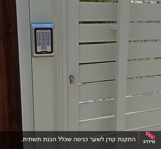 מקודד דיגיטלי מותקן על שער מתכת לבן
